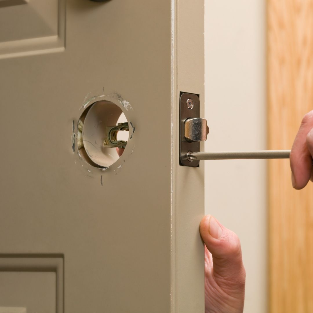 Locksmith fixing a broken door in Ealing