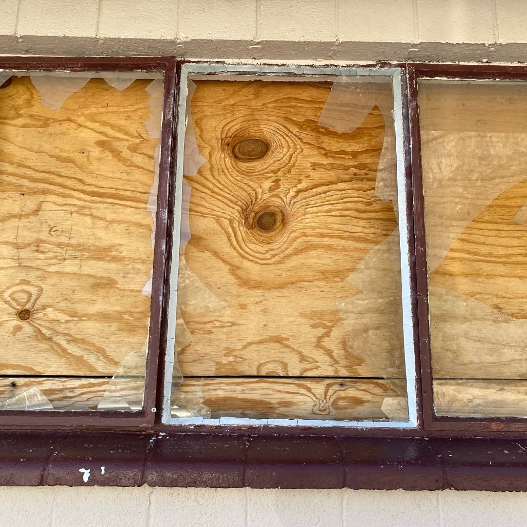 Broken window boarded up in Hounslow