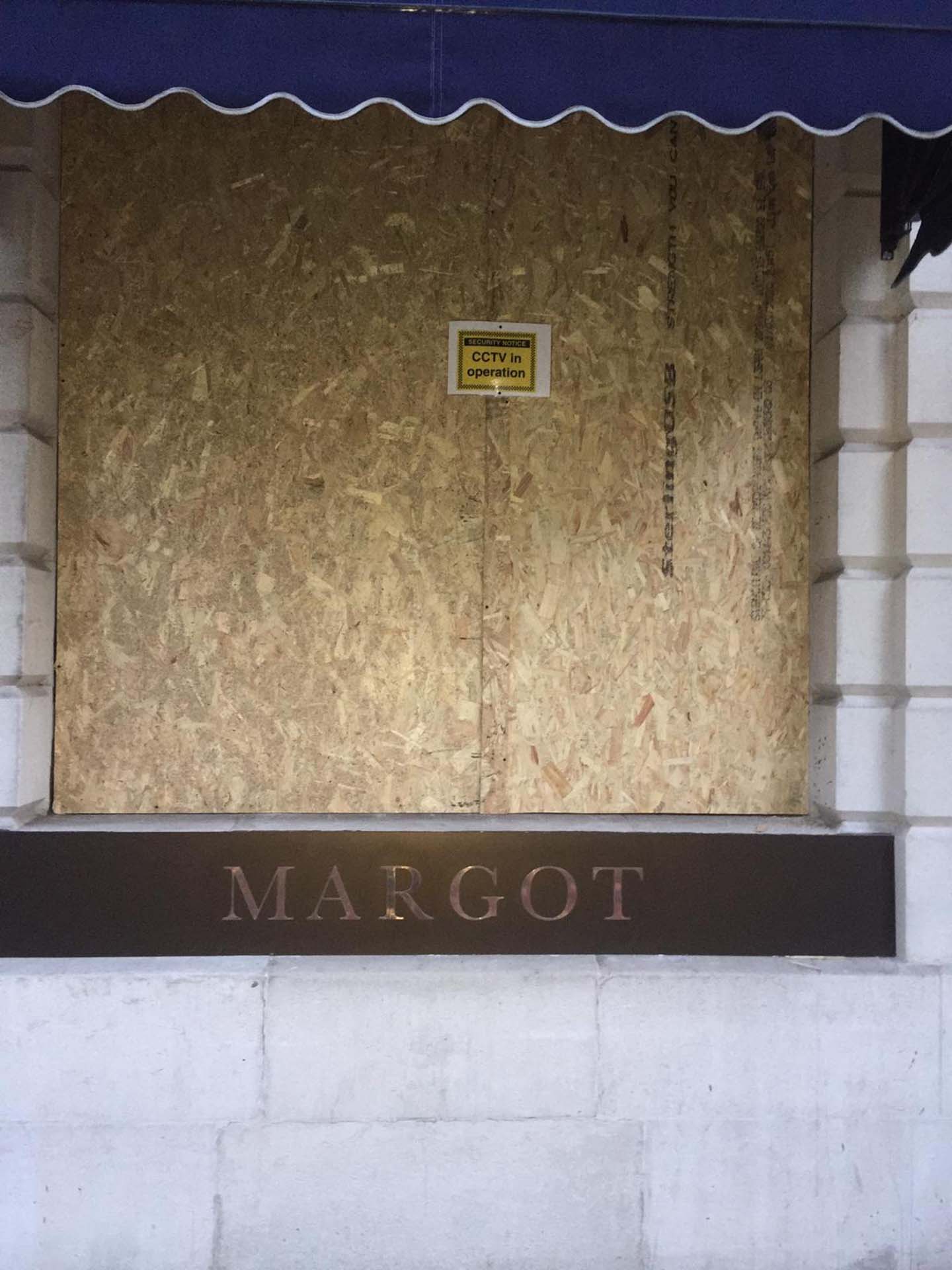 Boarded up restaurant windows.